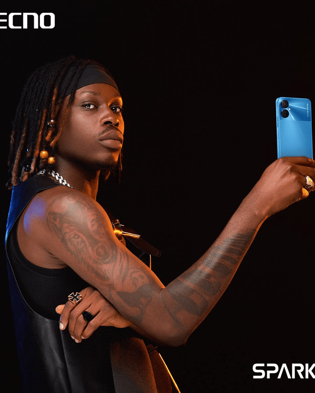 Fireboy DML holding a tecno device with his right hand